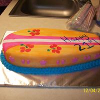 Surfboard birthday cake for a friend who likes surfboards and all of that fun stuff. it is fondant that has been painted. there are little flowers...