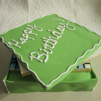 Crossword Cookie Box Cake Red velvet cake with vanilla frosting. Covered in green fondant and white RI accents. Inside are sugar cookies with fondant/RI decorations...