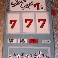 Lucky 7's Slot machine cake for a 65th birthday, hence the coins. Buttercream with fondant accents.