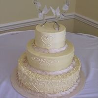 Buttercream Heart Round buttercream wedding cake. leaves are fondant with a touch of silver luster. our customer provided the topper.