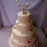 Champagne Bubbles Wedding Cake We copied this unique cake from a magazine that the bride gave us. It is covered in fondant and the "bubbles" are gumpaste.