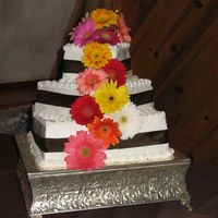 Jessica And Ryan's Wedding Cake 3 teir, square wedding cake. Chocolate brown ribbon around each cake, and fresh flowers!