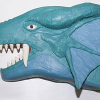 Yu-Gi-Oh's Dragon Timaens Chocolate cake carved to look like the dragon Timaens. Teeth are white chocolate candy clay. Ear is chocolate covered in buttercream. Half...