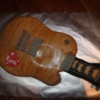 Wood Grain Electric Guitar White cake covered in Fondant. Cream color "painted" grain on with watered down coloring. Threaded crochet thread thru for...