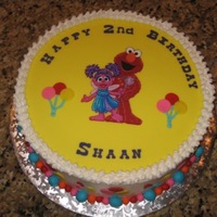 Elmo Birthday Cake The customer requested something basic with Elmo and Abby -- so used an edible image printed on gumpaste. Covered top with yellow fondant....