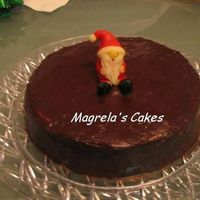 Simple Christmas Chocolate cake with chocolate filling and iced with chocolate ganache and sprinkled with chocolate sprinkles. Santa made of Marzipan. It...