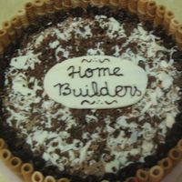 Bolos_086.jpg Top view. Yellow cake with chocolate filling and chocolate ganache icing. Wafers on the sides. White chocolate plaque.