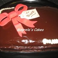 Sweet Gift Chocolate cake with coconut filling covered in chocolate ganache. The corners and tag are white chocolate and the bow is fondant. It was...