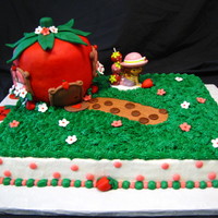 Strawberry Shortcake Strawberry Shortcake Cake. Iced in buttercream. Strawberry house is styrofoam covered in fondant.