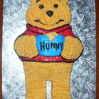 Winnie The Pooh carved sheet cake covered in buttercream icing.