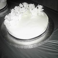White Wedding Cake With Flowers White cake with buttercream icing, black ribbon and flowers.