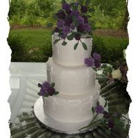 Purple Rose Wedding This is a 6", 8" and 10" wedding cake. Covered in fondant, piped fillagree work. Two shades of gumpaste roases were made....