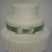 Pleats Dummy cake w/ pleats placed individually on cake, fondant lace and pearls. For practice and my display cabinet in my kitchen.