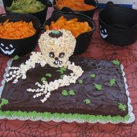 Skull Cake I did this cake for my halloween party it is chocolate cake and chocolate icing with a skull made out of popcorn and cookie crumbs for dirt...
