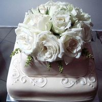 Two Tier Engagement Cake A two tier cake topped with fresh white roses.