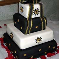 Ivory, Black And Gold Wedding Cake This is a four tier wedding cake for 200 covered with Stain Ice fondant and with all fondant accents. The gold accents were spray painted...