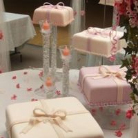 Quinceanera Cake Four presents made of fondant, colored in the shades of pink to match the decorations. Placed on stands with candles in the center. Not a...