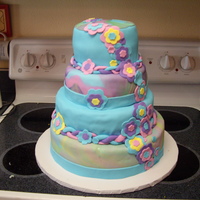 My Cousin's Wedding Cake light blue with 2 tie-dye layers. fondant flowers and a peace sign on the top. Even the inside was tie-dye.