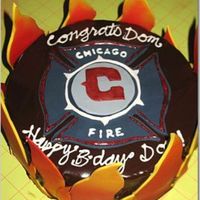 Chicago Fire Cake Chocolate cake, vanilla buttercream filling, covered in chocolate ganache. Flames made out of yellow fondant, sprayed with red color. Logo...