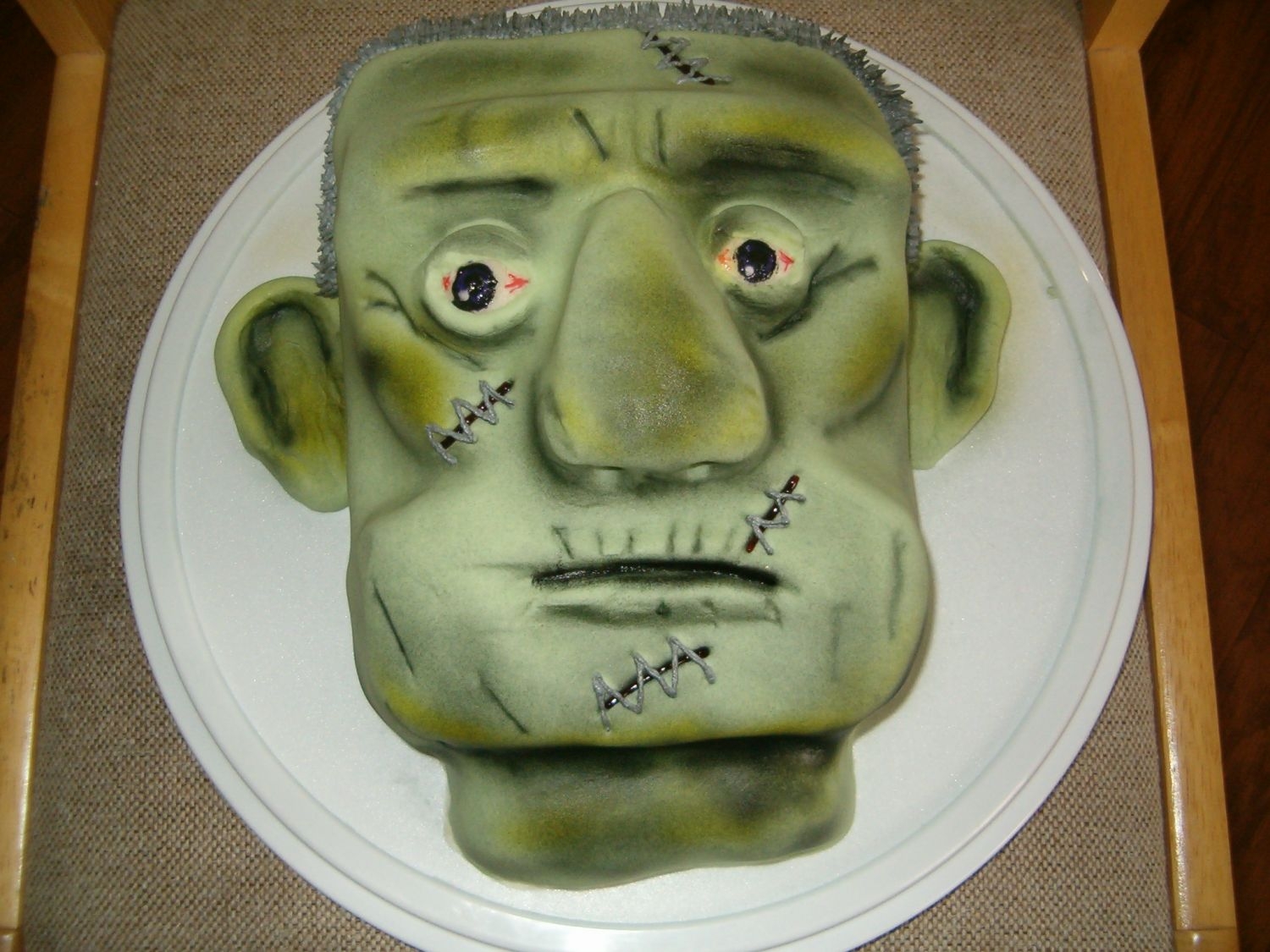 Frankenstein Yellow cake filled & frosted w/buttercream & finished in fondant & airbrushed.