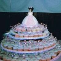 Sweet15.jpg Ok I posted this earler but this is a better pic. Quinceanera cupcake tree(300 cupcakes) with doll cake the tiara was also made of icing....