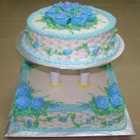 Blue And White 2-tier cake where the bottom cake is a 2kg chocolate moist cake & the top one is a 1kg vanilla buttercake. both are decorated in...