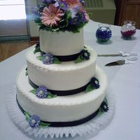 0627091225-02.jpg This was done in buttercream, Fondant/Gum Paste Gerbera Daisies, Gum Paste Leaves and Real Gerbera Daisy mix on top of cake. Bottom edging...