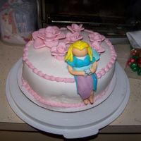 Fairy Cake almond flovred cake with buttercream icing between layers covered with MMF. Flowers and Fairy made from MMF.