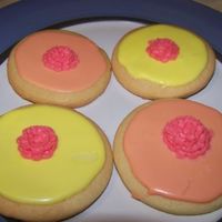 Round Decorative Sugar cookies flooded with royal icing decorated with a royal icing flower.