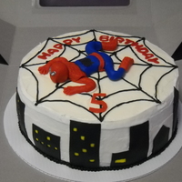 Spiderman This cake is yellow cake with vanilla icing, the buildings and spiderman are made of fondant and the web is hand piped icing.