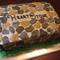 Herathstone cake made for a neighborhood function that copies the stone sign at the entrance. buttercream with fondant 'rocks'