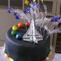 Space Cake Second in my series of 5 retirement cakes. Covered in black MMF and trimmed in marshmellows and star candies. Topped with a small space...