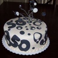 Mom's 50Th Birthday Cake Here is a picture of my Mom's fiftieth birthday cake. Fondant covered with fondant cutouts and a wired topper iwth fondant accents. It...