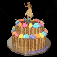 Hula Dancer 10 inch double and 8 inch single layer cakes stacked, frosted and adorned with Pirouette cookies, gumpaste flowers, and a Hawaiian dancer....