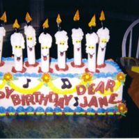 Singing Candles Loaf Cake w/ Buttercream icing, Garland and flowers.Candles from white dowel roads with buttercream features, licorice wicks, Letters and...