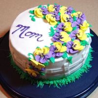 Pansies For Mom Buttercreme icing with Royal Icing Pansies made in advanced. Went one step further and added the 'mustache' look to them....