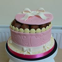 Chocolate Box Gift Chocolate sponge covered in sugarpaste with gumpaste bows. The lid was card covered in sugarpaste. The chocolates were bought.