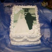 The Kiss Buttercream icing on a 9x13 with a edible image. This cake works great for a 1st anniversary cake. (Picture from the wedding show I was in...