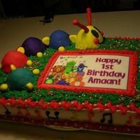 Baby Einstein Caterpillar Poor lighting in the picture. The music notes on the side are dark purple, orange and yellow. Catterpillar is covered with fondant....