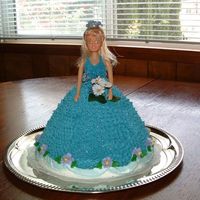 Doll Cake Did this way back in 2003 when I took my cake decorating class. All buttercream, mini silk flowers...just a whole cake, not torted. I think...