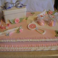 Girly Baby Shower I love the way this one turned out. Regular buttercream with fondant/gumpaste accents. Package cake is a mud cake covered in fondant.