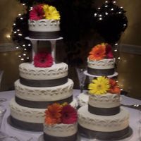 First Wedding Cake This was my first wedding cake that I made. All buttercream icing. Black sheer ribbon around each tier base. Fresh gerber daisies as...