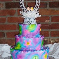 Tye-Dyed Wedding Cake tye-dyed wedding cake done with airbrush and sugar smiley faces set into the daisy shapes.