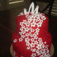 Michelle Birthday Cake Cake covered with red fondant and white and red fondant flowers. cake piped with red cornelli lace.