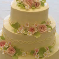 Buttercream/ Pastel Colored Sugar Flower Wedding Cake All buttercream with fondant and gumpaste roses and flowers. Lemon cake with fresh raspberries for filling.