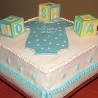 Baby Shower Cake My first Baby Shower cake. Onesie made out of fondant. Building blocks spelling baby's name made out of gum paste with fondant accents...