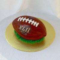 Super Bowl Xlii Football Yellow cake with chocolate icing. Made from a 9x13 sheet that was cut in half, stacked and carved. All buttercream with fondant accents....