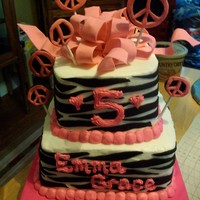 Zebra Stripes W/ Peace Signs Two tiered square w/ zebra stripes and peace signs. Peace signs are made from fondant on sucker sticks.