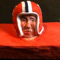 Football Player Helmet And Jersey Player face made from buttercream. Jersey and helmet are fondant. Didn't have enough time for the face guard.