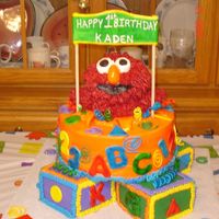 Elmo Four baby blocks with 10" on top. Elmo is rice crispy with bc fur. Accents are fondant.